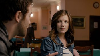 Movie still from “Chernobyl Diaries” (2012), directed by Bradley Parker – A man and a woman sitting at a table talking to each other; Close Up shot, Over the shoulder angle
