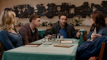 Movie still from “Chernobyl Diaries” (2012), directed by Bradley Parker – Two men sitting at a table in front of plates of food; Medium shot, Over the shoulder angle