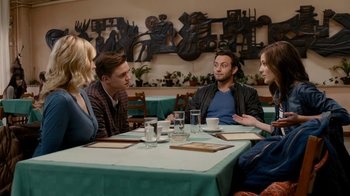 Movie still from “Chernobyl Diaries” (2012), directed by Bradley Parker – A group of people sitting at a table talking to each other; Medium shot, Over the shoulder angle