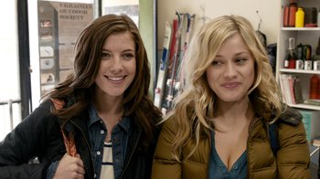 Movie still from “Chernobyl Diaries” (2012), directed by Bradley Parker – Two young women smile for the camera while posing for a picture; Close Up shot, Over the shoulder angle