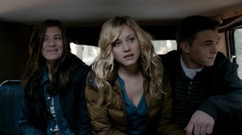 Movie still from “Chernobyl Diaries” (2012), directed by Bradley Parker – A woman sitting in a car next to two other people; Medium shot, Over the shoulder angle
