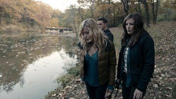 Movie still from “Chernobyl Diaries” (2012), directed by Bradley Parker – A group of people walking near a body of water; Medium shot, High angle
