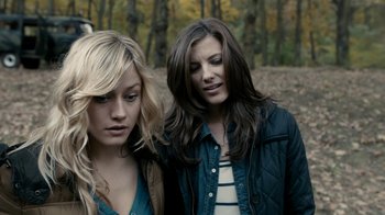 Movie still from “Chernobyl Diaries” (2012), directed by Bradley Parker – Two young women standing next to each other in the woods; Close Up shot, Over the shoulder angle
