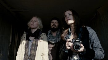 Movie still from “Chernobyl Diaries” (2012), directed by Bradley Parker – A group of people standing next to each other holding a camera; Medium shot, Low angle