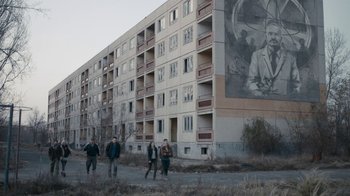 Movie still from “Chernobyl Diaries” (2012), directed by Bradley Parker – A group of people walking in front of a building; Extreme Wide shot, Low angle