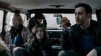 Movie still from “Chernobyl Diaries” (2012), directed by Bradley Parker – A group of people sitting in the back of a car; Medium shot, Over the shoulder angle