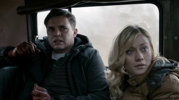 Movie still from “Chernobyl Diaries” (2012), directed by Bradley Parker – A man and a woman sitting next to each other in a car; Medium shot, Over the shoulder angle