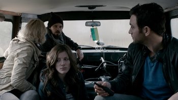 Movie still from “Chernobyl Diaries” (2012), directed by Bradley Parker – A group of people sitting in the back of a car; Medium shot, Over the shoulder angle
