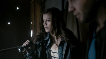 Movie still from “Chernobyl Diaries” (2012), directed by Bradley Parker – A woman holding a microphone in front of a man; Medium shot, Over the shoulder angle