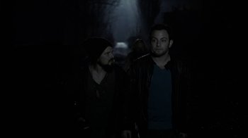 Movie still from “Chernobyl Diaries” (2012), directed by Bradley Parker – A couple of men standing next to each other in the dark; Medium shot, Over the shoulder angle