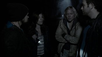Movie still from “Chernobyl Diaries” (2012), directed by Bradley Parker – Three people standing in the dark near one another; Medium shot, Over the shoulder angle