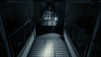 Movie still from “Chernobyl Diaries” (2012), directed by Bradley Parker – A dark hallway with a light shining on it; Extreme Wide shot, High angle