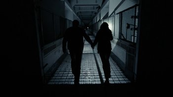 Movie still from “Chernobyl Diaries” (2012), directed by Bradley Parker – Two people holding hands while walking down a hallway; Wide shot, Low angle
