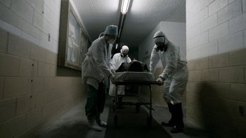 Movie still from “Chernobyl Diaries” (2012), directed by Bradley Parker – A group of people in a room with a bed; Wide shot, Low angle