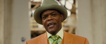 Movie still from “Chi-Raq” (2015), directed by Spike Lee – An older man wearing an orange suit and a green hat; Close Up shot, Low angle