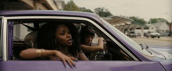 Movie still from “Chi-Raq” (2015), directed by Spike Lee – Two women in a purple car looking out of the window; Medium shot, Over the shoulder angle
