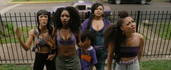 Movie still from “Chi-Raq” (2015), directed by Spike Lee – A group of women standing next to each other near a fence; Medium shot, Over the shoulder angle