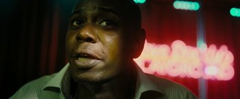 Movie still from “Chi-Raq” (2015), directed by Spike Lee – A man's face in front of neon lights; Close Up shot, Low angle