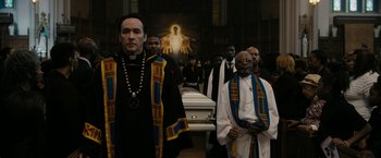 Movie still from “Chi-Raq” (2015), directed by Spike Lee – A group of people standing in front of a casket in a church; Medium shot, High angle