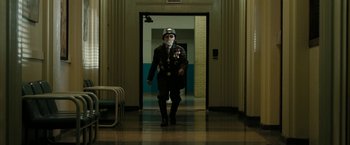 Movie still from “Chi-Raq” (2015), directed by Spike Lee – A man in a uniform walking down a hall way; Wide shot, Low angle
