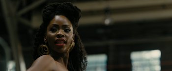 Movie still from “Chi-Raq” (2015), directed by Spike Lee – A woman in a black top and a black and white background; Close Up shot, Over the shoulder angle