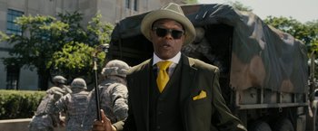 Movie still from “Chi-Raq” (2015), directed by Spike Lee – A man in a suit and tie holding a umbrella; Medium shot, Low angle