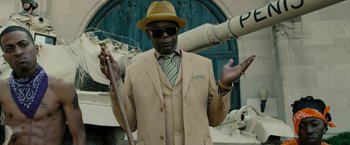 Movie still from “Chi-Raq” (2015), directed by Spike Lee – A man in a suit and hat holding a cane; Medium shot, Low angle