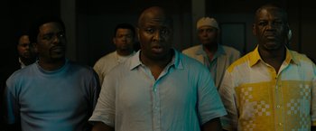 Movie still from “Chi-Raq” (2015), directed by Spike Lee – A group of men standing next to each other in a room; Medium shot, Low angle