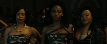 Movie still from “Chi-Raq” (2015), directed by Spike Lee – A woman in a camouflage dress with a purse in front of her face; Close Up shot, Over the shoulder angle