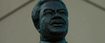 Movie still from “Chi-Raq” (2015), directed by Spike Lee – The face of a statue of a man; Extreme Close Up shot, Low angle