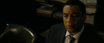 Movie still from “Chi-Raq” (2015), directed by Spike Lee – A person wearing a suit and tie; Close Up shot, High angle