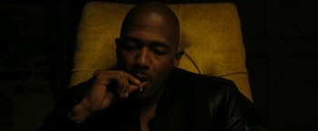 Movie still from “Chi-Raq” (2015), directed by Spike Lee – A man sitting on a couch with his hand to his mouth; Close Up shot, High angle