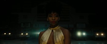 Movie still from “Chi-Raq” (2015), directed by Spike Lee – A woman in a gold dress is posing for a picture; Close Up shot, Low angle