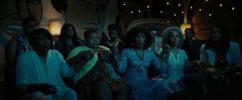 Movie still from “Chi-Raq” (2015), directed by Spike Lee – A group of people sitting in a room; Wide shot, High angle
