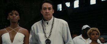 Movie still from “Chi-Raq” (2015), directed by Spike Lee – A man wearing a white shirt and a black necklace; Close Up shot, Low angle