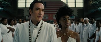 Movie still from “Chi-Raq” (2015), directed by Spike Lee – A man and a woman standing next to each other in front of an american flag; Close Up shot, Low angle