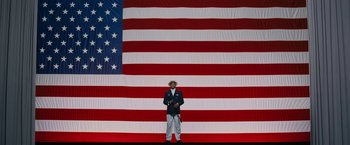 Movie still from “Chi-Raq” (2015), directed by Spike Lee – A man standing in front of an american flag; Wide shot, Low angle