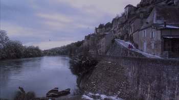Movie still from “Chocolat” (2000), directed by Lasse Hallström – A boat on a river near a city; Extreme Wide shot, High angle