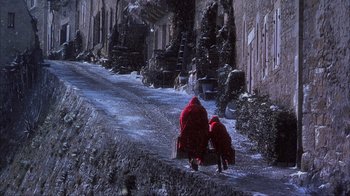 Movie still from “Chocolat” (2000), directed by Lasse Hallström – A couple of people walking down a snowy street; Wide shot, High angle
