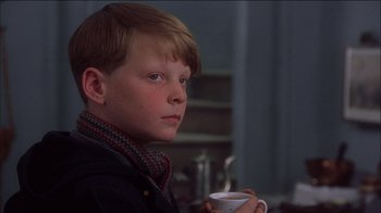 Movie still from “Chocolat” (2000), directed by Lasse Hallström – A young boy is holding a cup of coffee; Close Up shot, Low angle