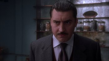 Movie still from “Chocolat” (2000), directed by Lasse Hallström – A man with a mustache wearing a suit; Close Up shot, Low angle