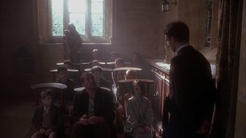 Movie still from “Chocolat” (2000), directed by Lasse Hallström – A group of people sitting in a room; Wide shot, High angle