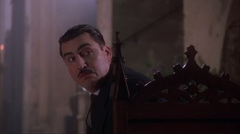 Movie still from “Chocolat” (2000), directed by Lasse Hallström – A person wearing a suit and tie; Close Up shot, Low angle