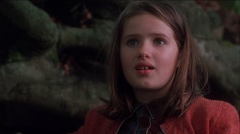 Movie still from “Chocolat” (2000), directed by Lasse Hallström – A young girl in a red sweater and a plaid tie; Close Up shot, Low angle