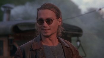 Movie still from “Chocolat” (2000), directed by Lasse Hallström – A person wearing sunglasses and a leather jacket; Close Up shot, Over the shoulder angle