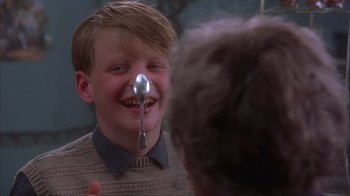 Movie still from “Chocolat” (2000), directed by Lasse Hallström – A young boy with a spoon in his mouth; Close Up shot, Over the shoulder angle