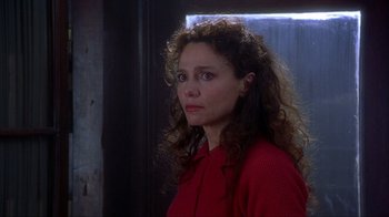 Movie still from “Chocolat” (2000), directed by Lasse Hallström – A person with curly hair wearing a red shirt; Close Up shot, Over the shoulder angle
