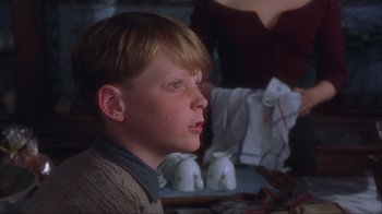 Movie still from “Chocolat” (2000), directed by Lasse Hallström – A young boy sitting in front of a tea set; Close Up shot, Low angle