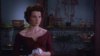 Movie still from “Chocolat” (2000), directed by Lasse Hallström – A woman in a red dress holding something in her hand; Medium shot, Low angle