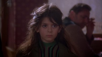 Movie still from “Chocolat” (2000), directed by Lasse Hallström – A young girl with long brown hair wearing a green sweater; Close Up shot, Over the shoulder angle